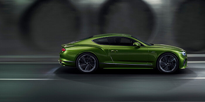  Gohm Sportwagen GmbH | Bentley Singen Bentley Continental GT coupe in Tourmaline Green paint driving in profile on a dark road