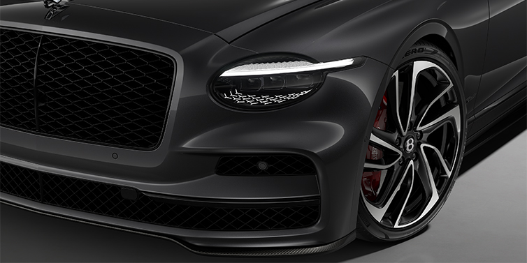Gohm Sportwagen GmbH | Bentley Singen New Bentley Flying Spur Speed sedan head lamp against Magnetic paint with 22" Swept spoke Black & Machined wheel
