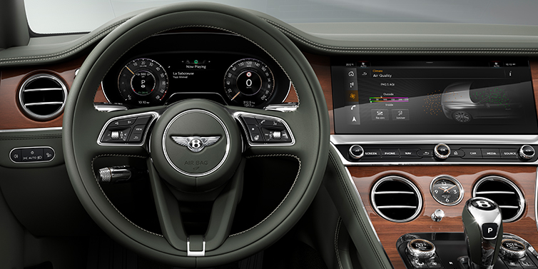 Gohm Sportwagen GmbH | Bentley Singen New Bentley Continental GT coupe steering wheel and front cabin view in Cumbrian Green hide and Crown Cut walnut veneer